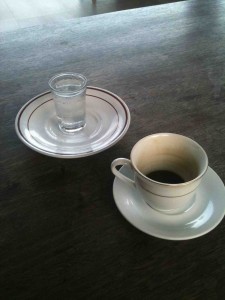 Cup and glass of grappa on table
